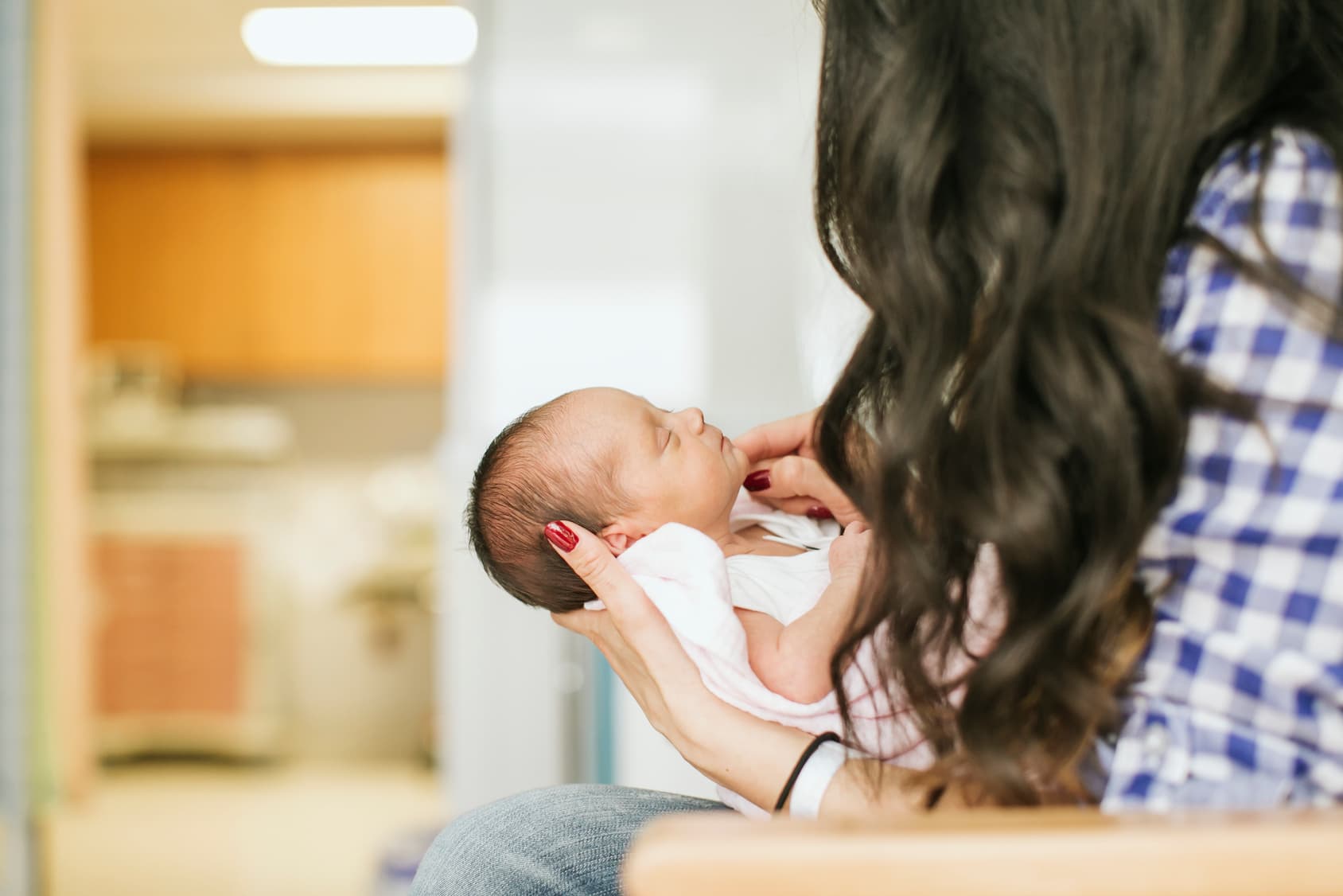 Premature infant being gently held in a clinical setting